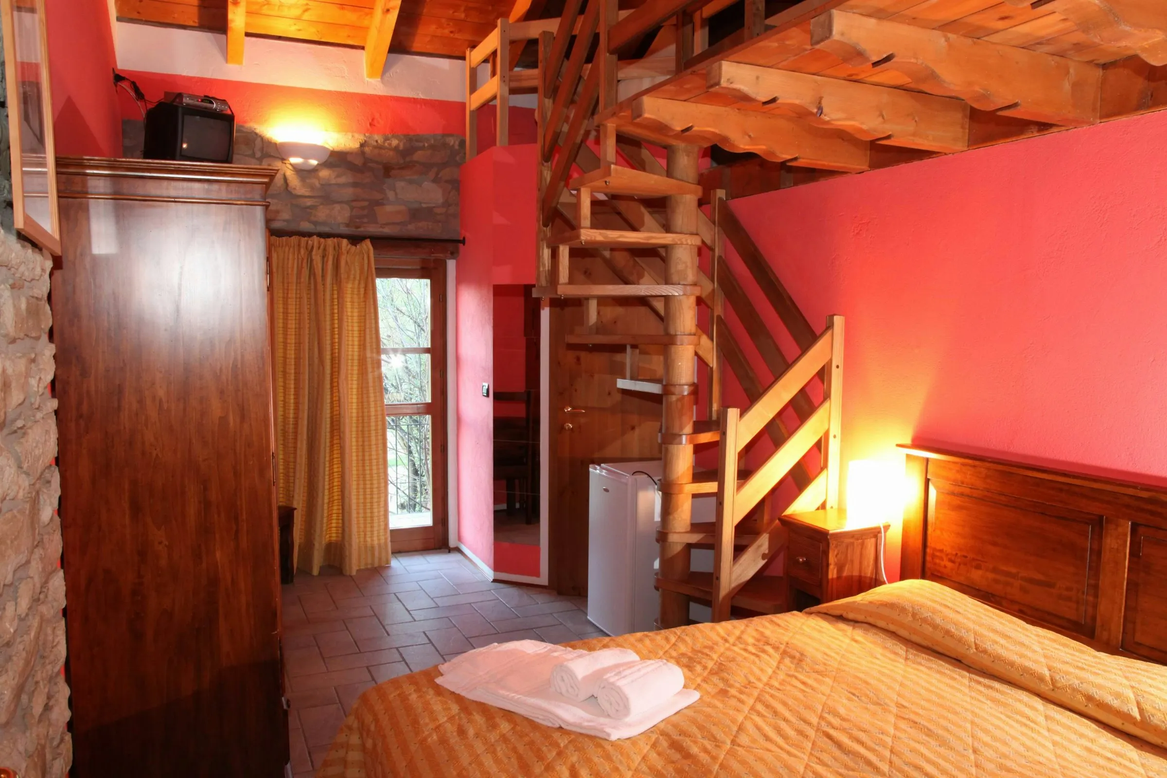 Wohnraum mit Doppelbett und Treppe