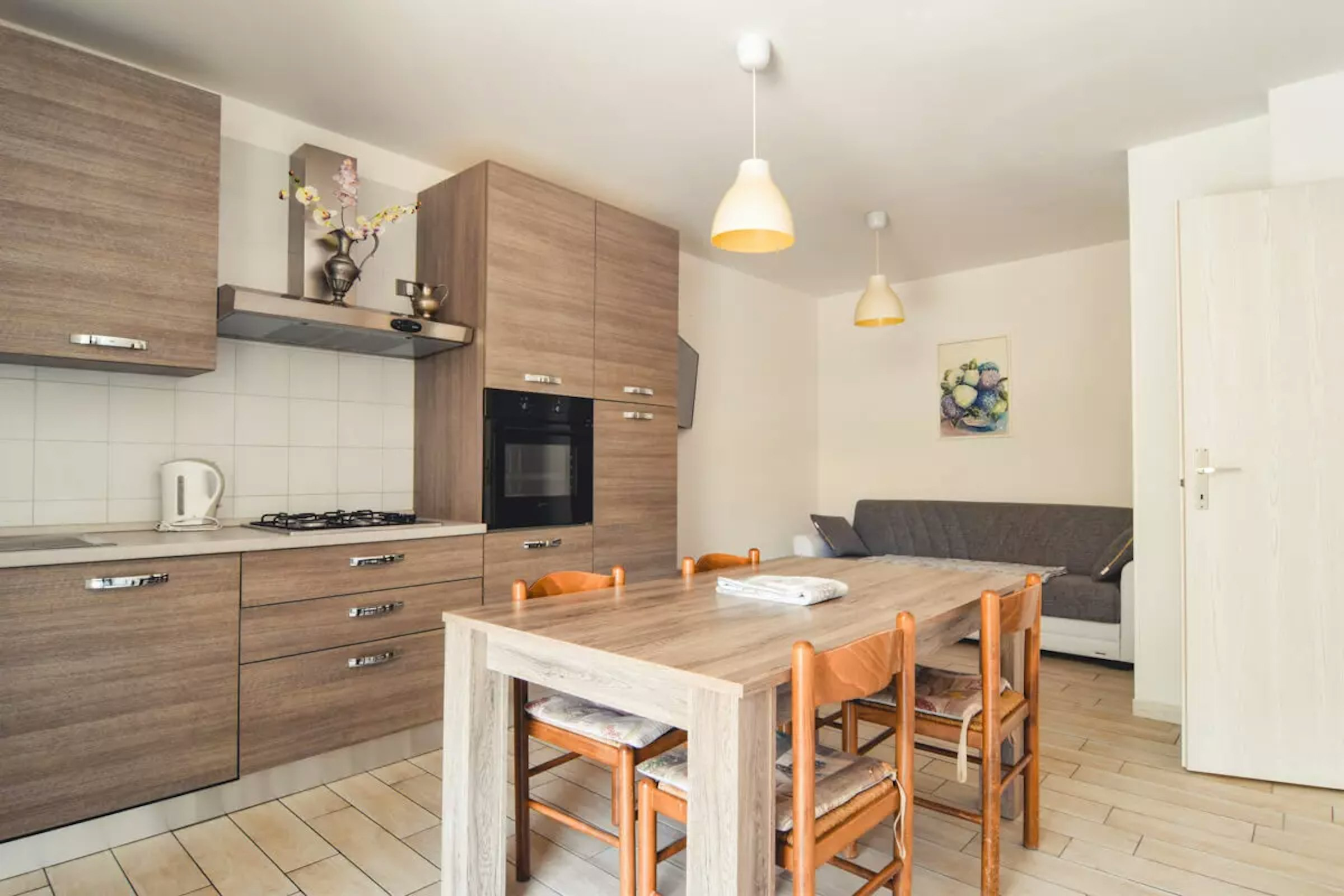 Ansicht der Ferienwohnung – Küchenzeile mit Esstisch und Sofa