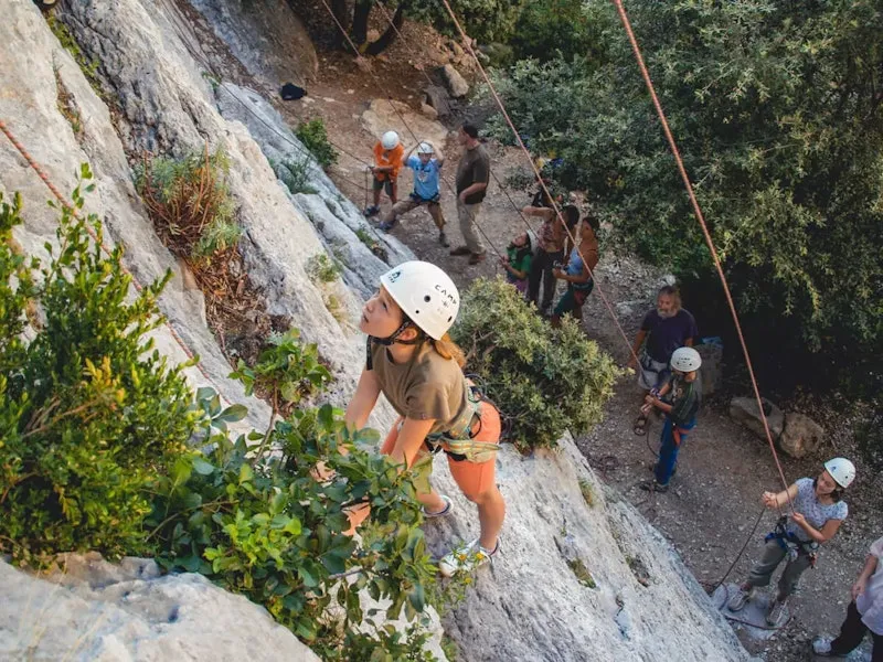 Erwachsene und Kinder beim Klettern an einer Felswand