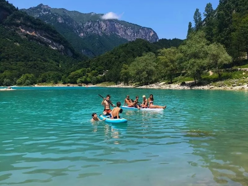 Kinder die Kajak fahren auf einem See umgeben von Bergen