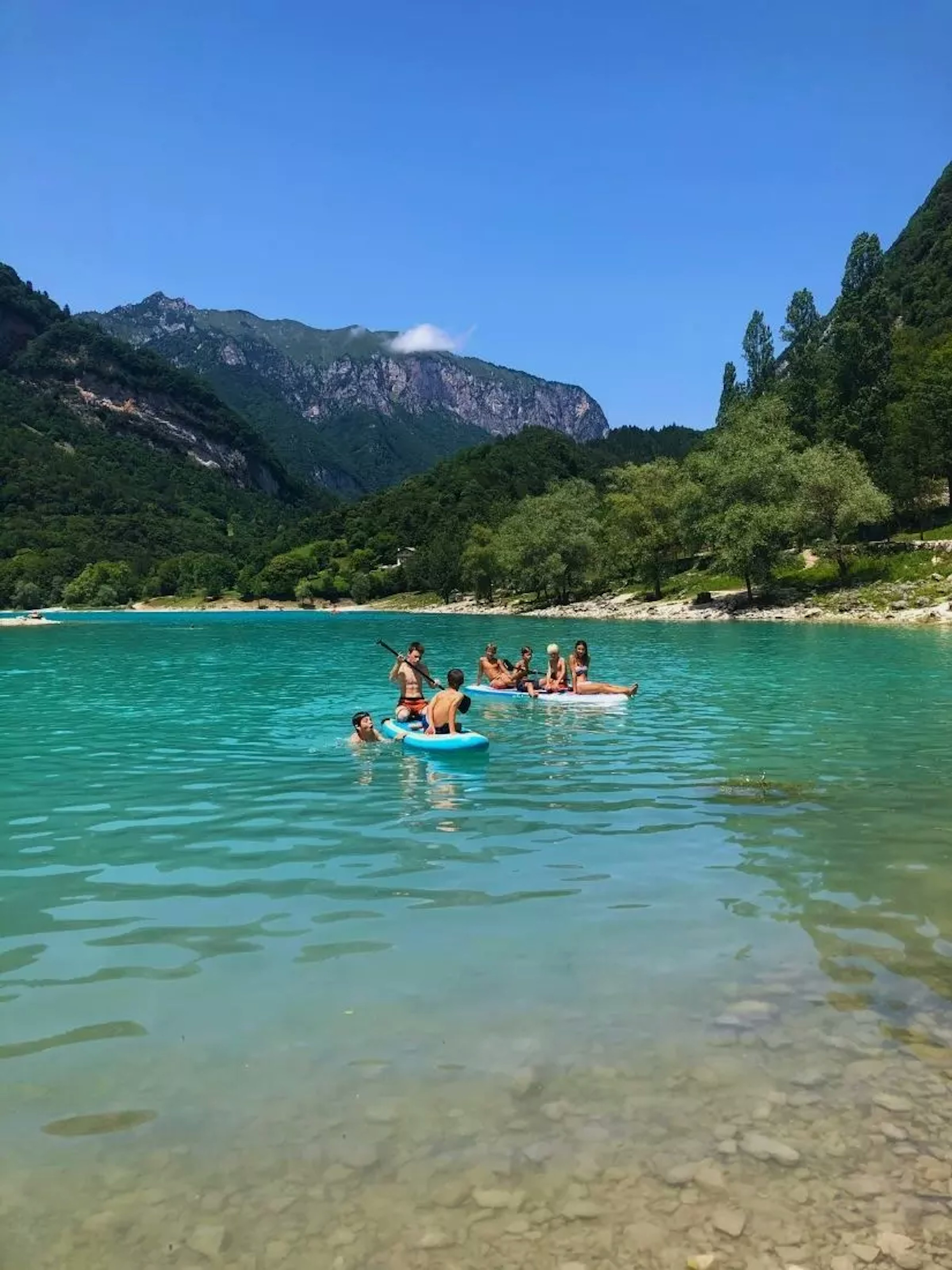 Kinder die Kajak fahren auf einem See umgeben von Bergen