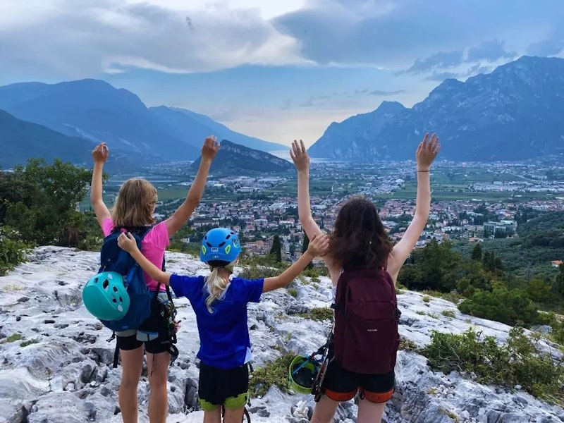 Drei Menschen reißen die Arme hoch und freuen sich über die schönen Berge