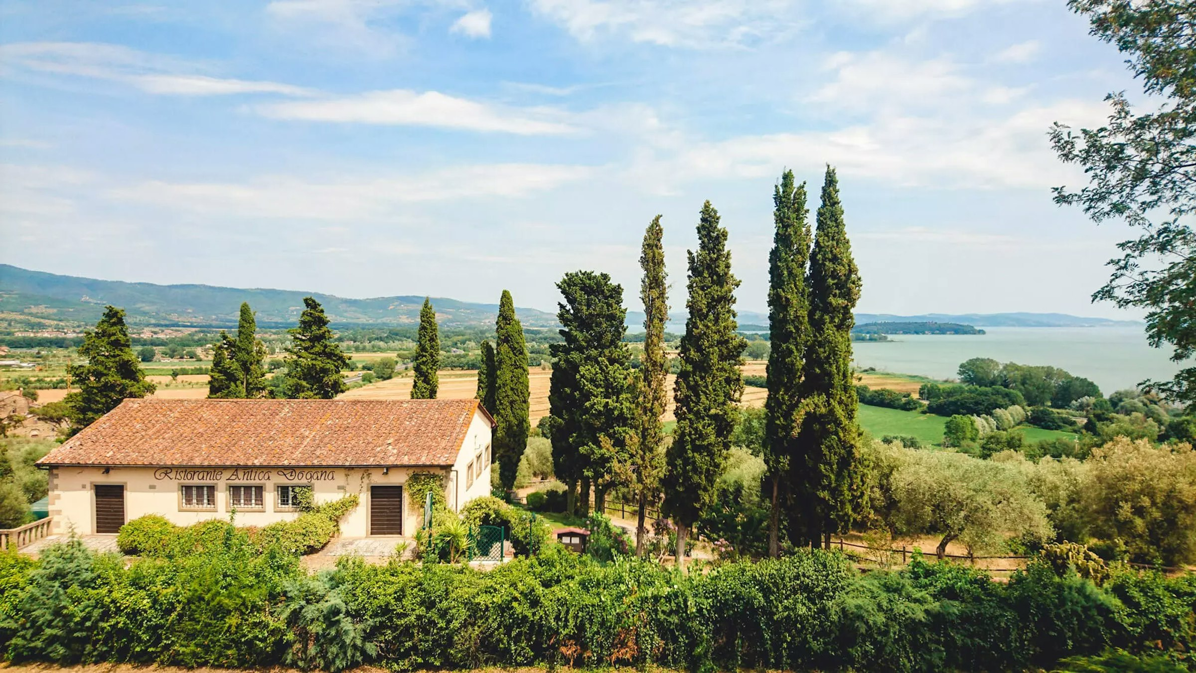 Ein Sandsteinhaus und Zypressen