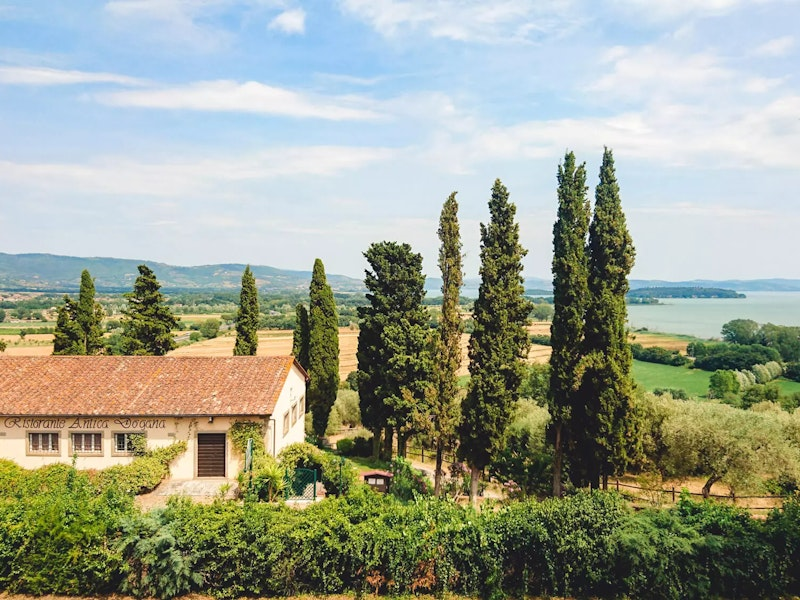 Ein Sandsteinhaus und Zypressen
