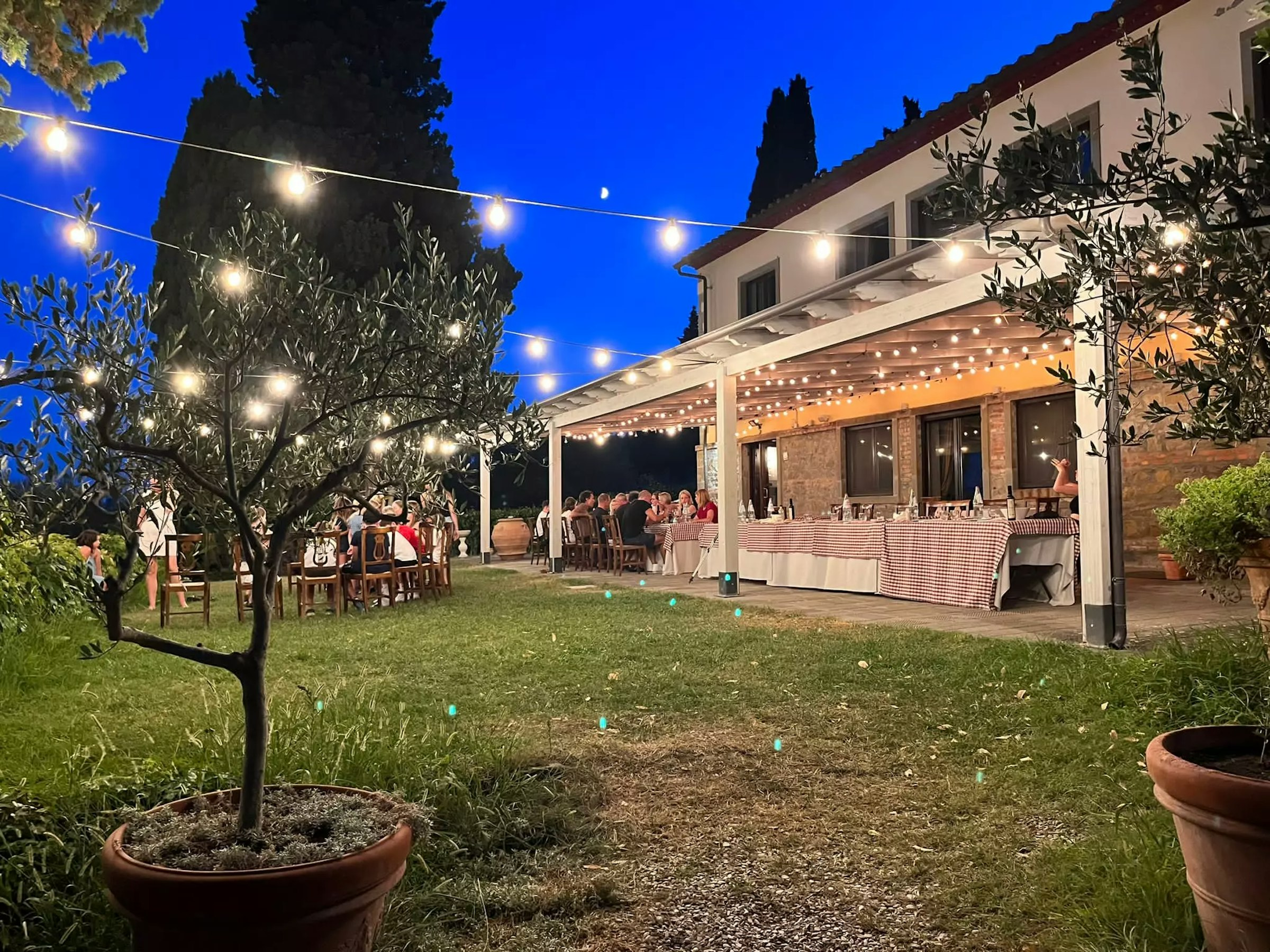 Die mit Lichetrketten erleuchtete Terrasse voller Menschen