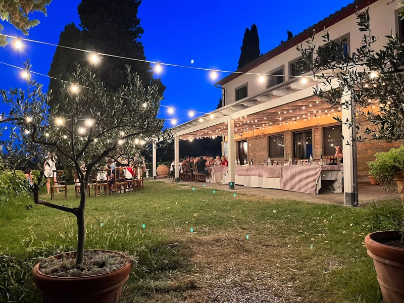 Die mit Lichetrketten erleuchtete Terrasse voller Menschen