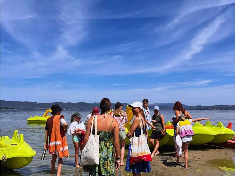 Reisegruppe mit Jugendlichen und Kinedrn am See auf den Weg zum Bootfahren
