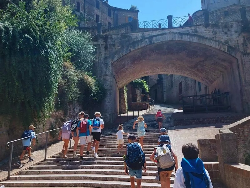 Gruppe von Kindern steigt eine alte Steintreppe in einer Altstadt hoch