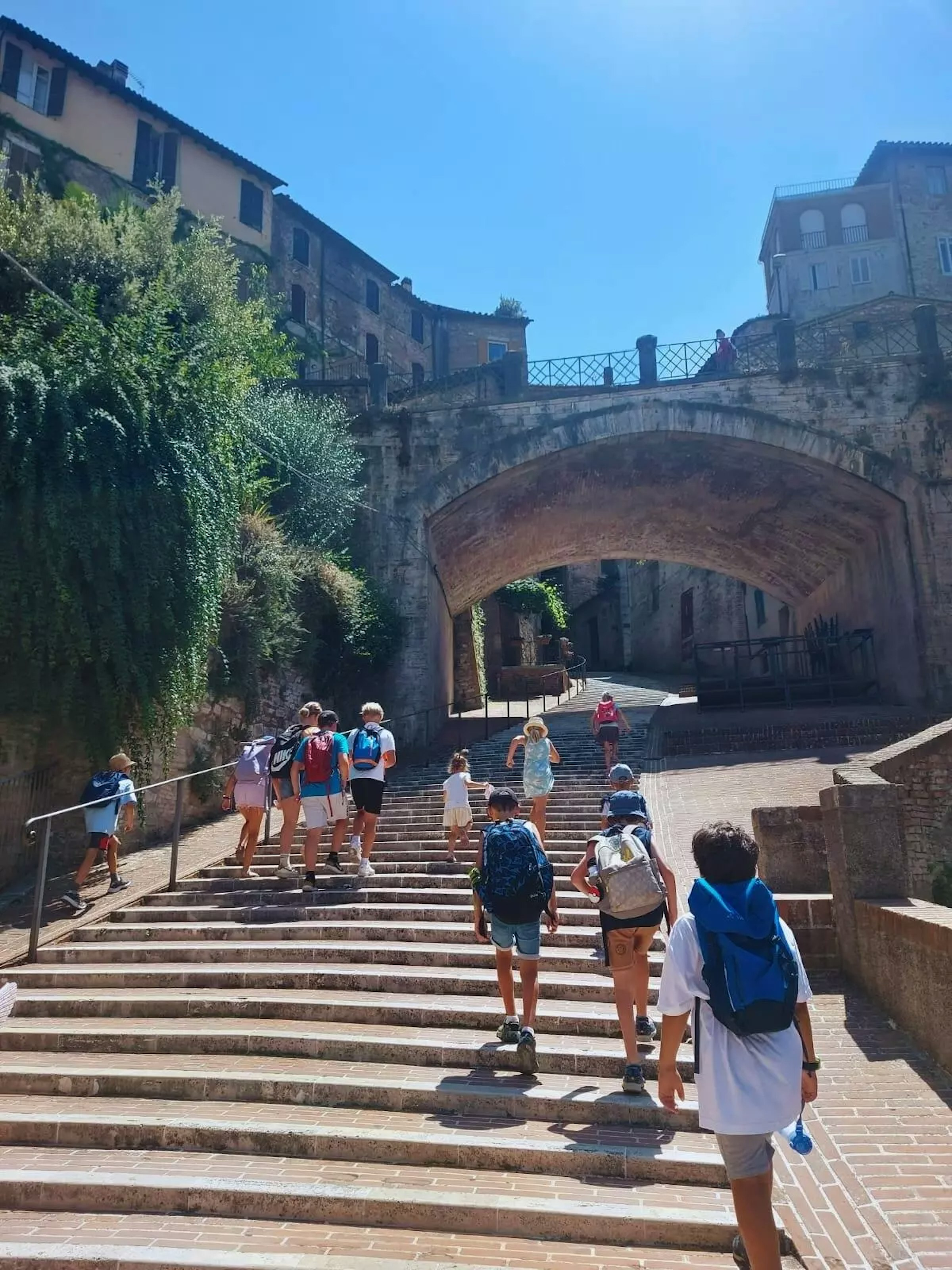 Gruppe von Kindern steigt eine alte Steintreppe in einer Altstadt hoch