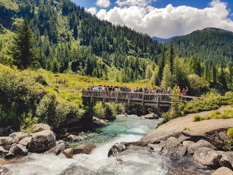Menschen auf einer Brücke am sprudelnden Fluss