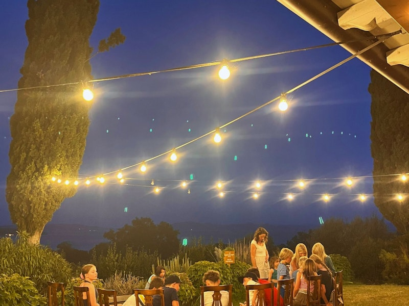 Kinder sitzen abends im Stuhlkreis