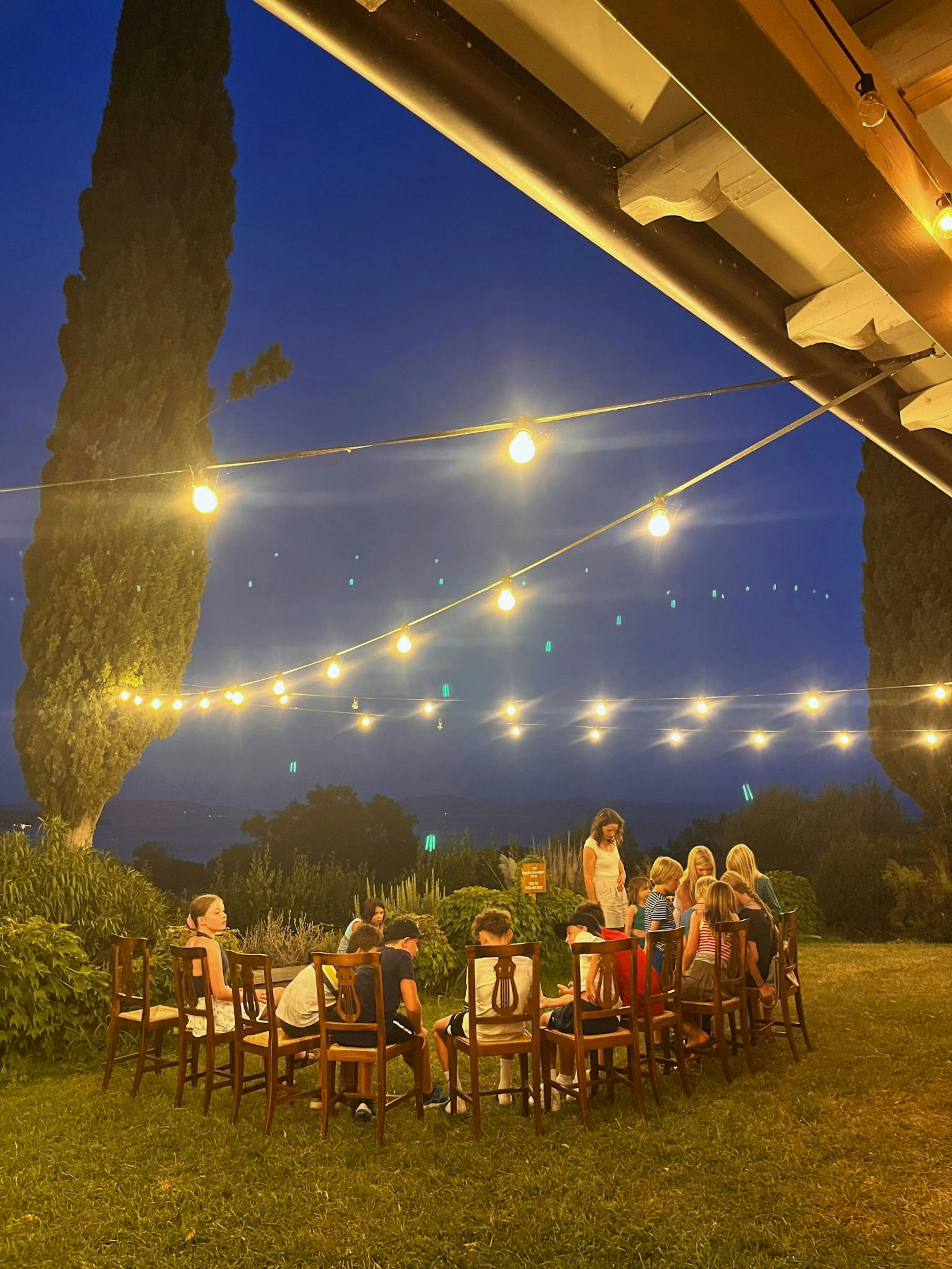 Kinder sitzen abends im Stuhlkreis