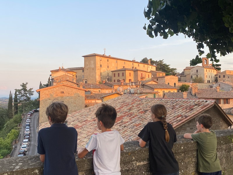 Kinder stehen an einer Stadtmauer