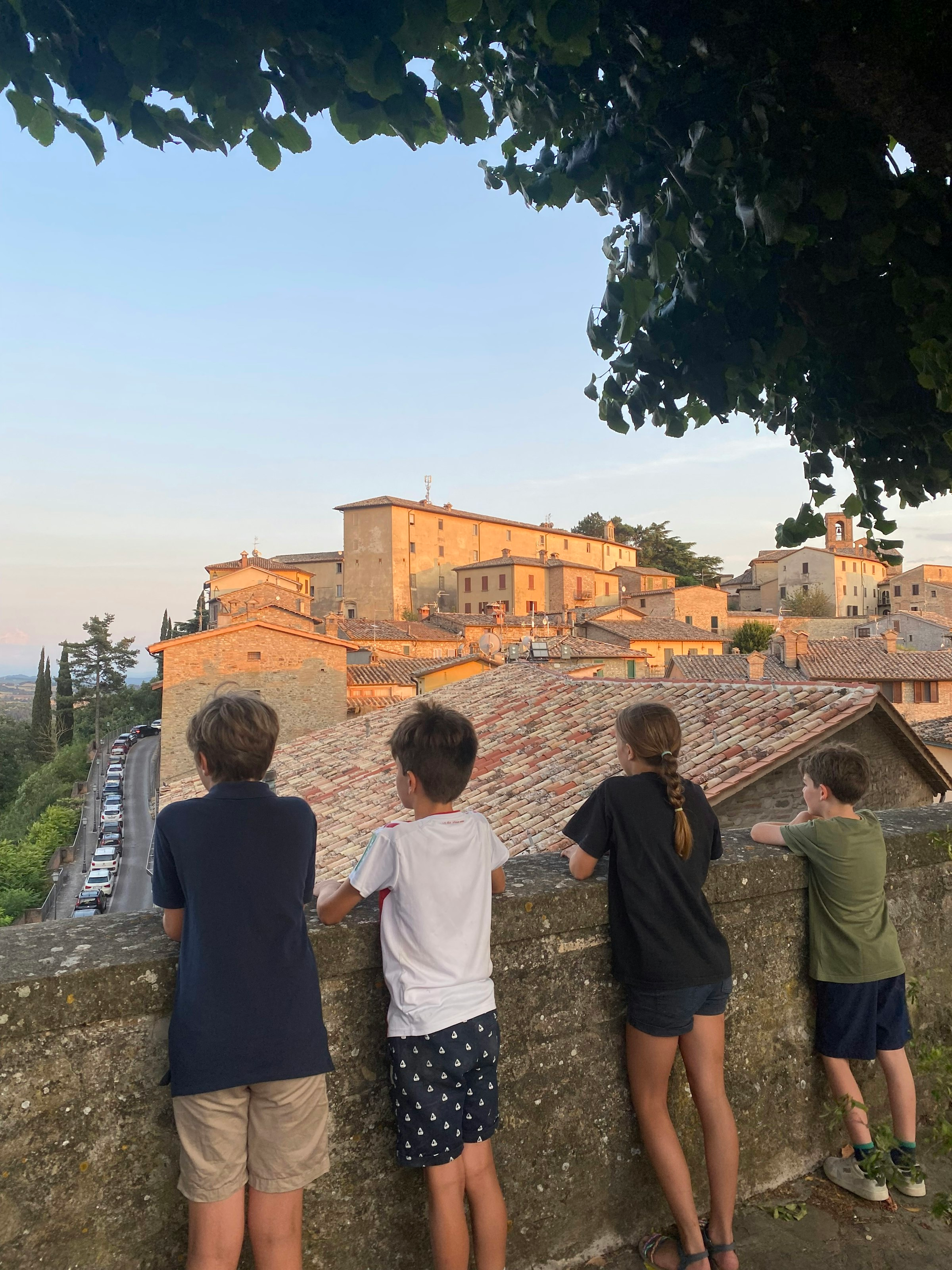 Kinder stehen an einer Stadtmauer